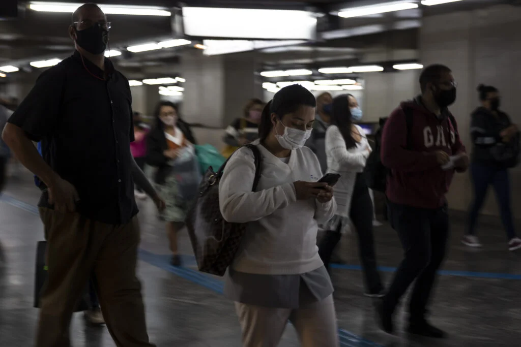 SAO PAULO, SP, 29.07.2020: ENSAIO - COTIDIANO -  NOVO  NORMAL - Ensaio sobre o novo normal no cotidiano de São Paulo, imposto pela pandemia do novo coronavírus e as medidas restritivas de segurança. Na foto, usuária do metrô, de máscara, caminha nos corredores da Estação da Luz enquanto olha no celular. (Foto: Mathilde Missioneiro/Folhapress) **EXCLUSIVO FOLHA**