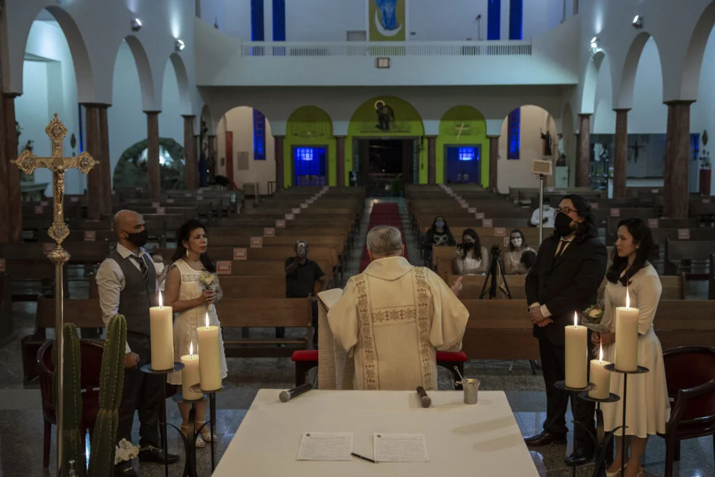 SAO PAULO, SP, 29.08.2020: ENSAIO - COTIDIANO -  NOVO  NORMAL - Ensaio sobre o novo normal no cotidiano de São Paulo, imposto pela pandemia do novo coronavírus e as medidas restritivas de segurança. Na foto, o Diácono Francisco Cavanha celebra um casamento comunitário na vazia Paróquia São Luís Gonzaga, na Vila Pereira Barreto, com os noivos Antonio Marcos Alves de Araújo (45) e Maria da Conceição Abreu (52) à esquerda da foto e Bruno Queiroz (31) e Patricia Midori (32) à direita da foto. Igrejas e paróquias tem retomado cerimônias de casamentos com uso opcional de máscara para os noivos e número de convidados reduzido. (Foto: Mathilde Missioneiro/Folhapress) **EXCLUSIVO FOLHA**